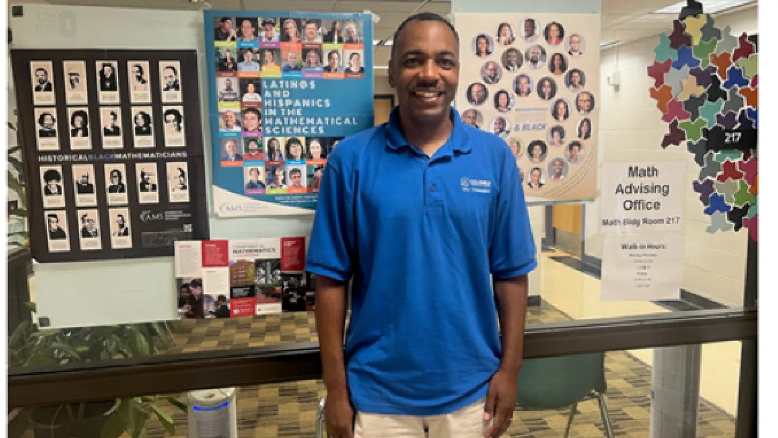 Picture of Johnathan Baker with a poster behind him. 