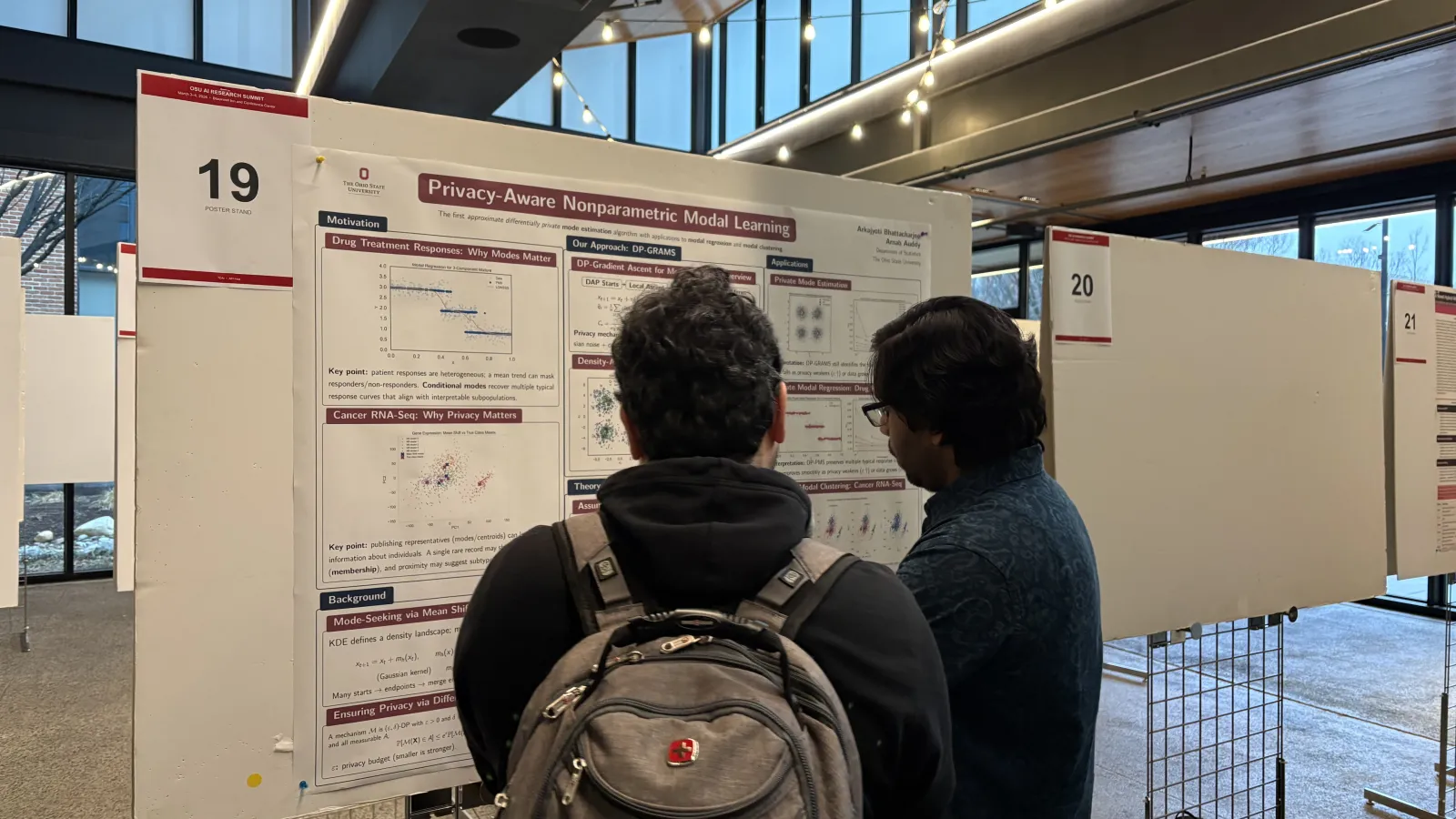 two students looking at a project board