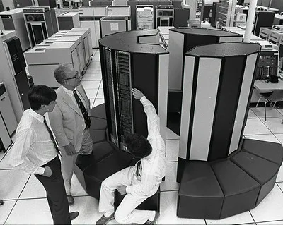 Three people standing around a super computer