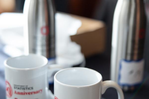 two mugs and water bottles sitting on a table