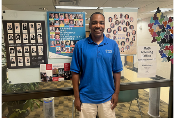 Picture of Johnathan Baker with a poster behind him. 