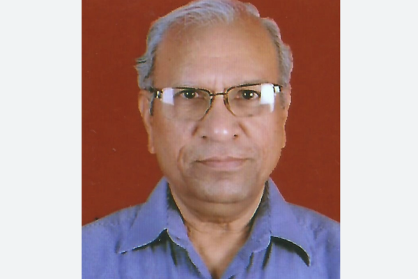 Abhaya Indrayan in front of a red backdrop