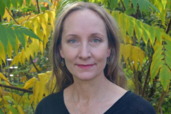 Geraldine Wright standing in front of a green plant