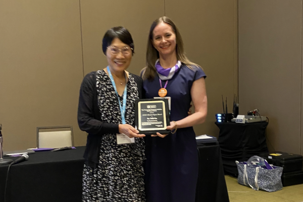 Shili Lin with a plaque at the JSM