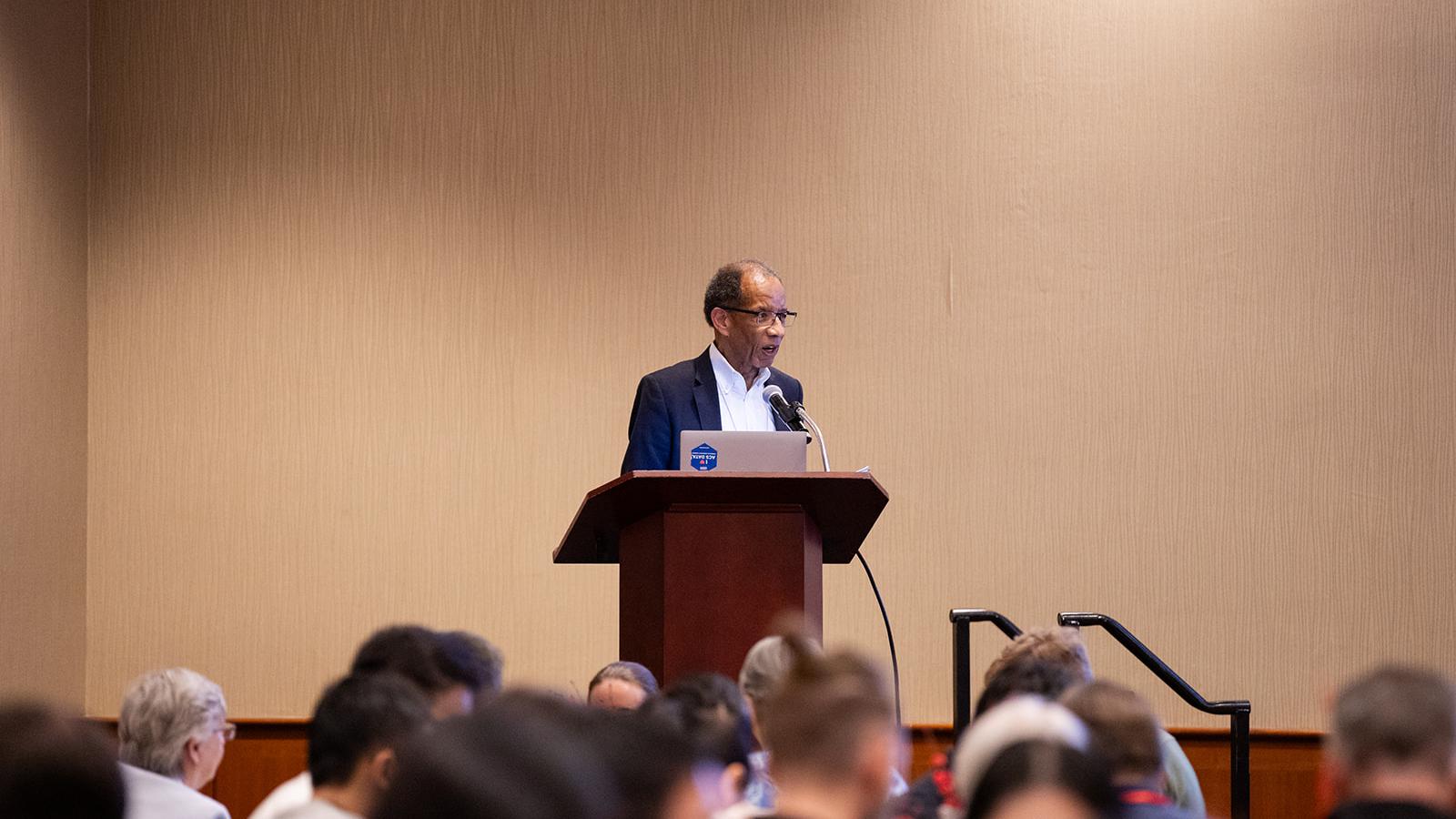 Keynote lecturer Tommy Wright standing at a podium delivering a presentation