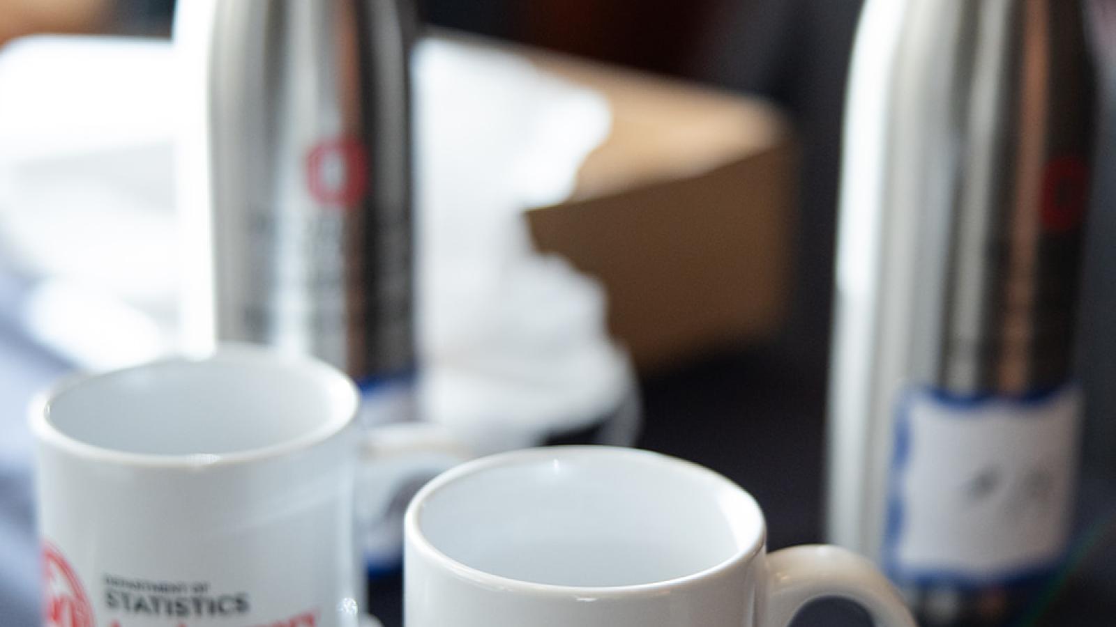 two mugs and water bottles sitting on a table