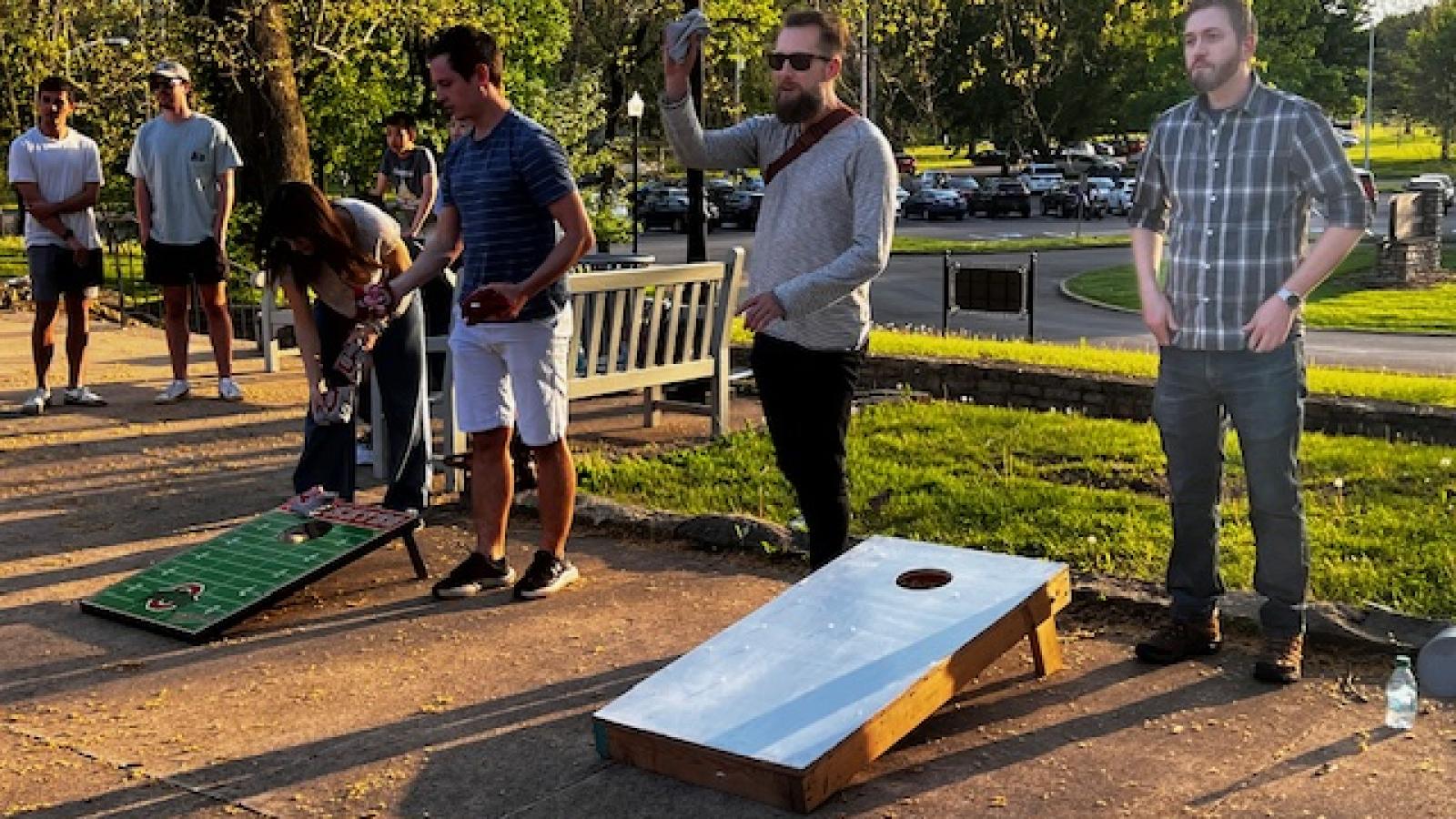 4 cornhole participants standing at boards