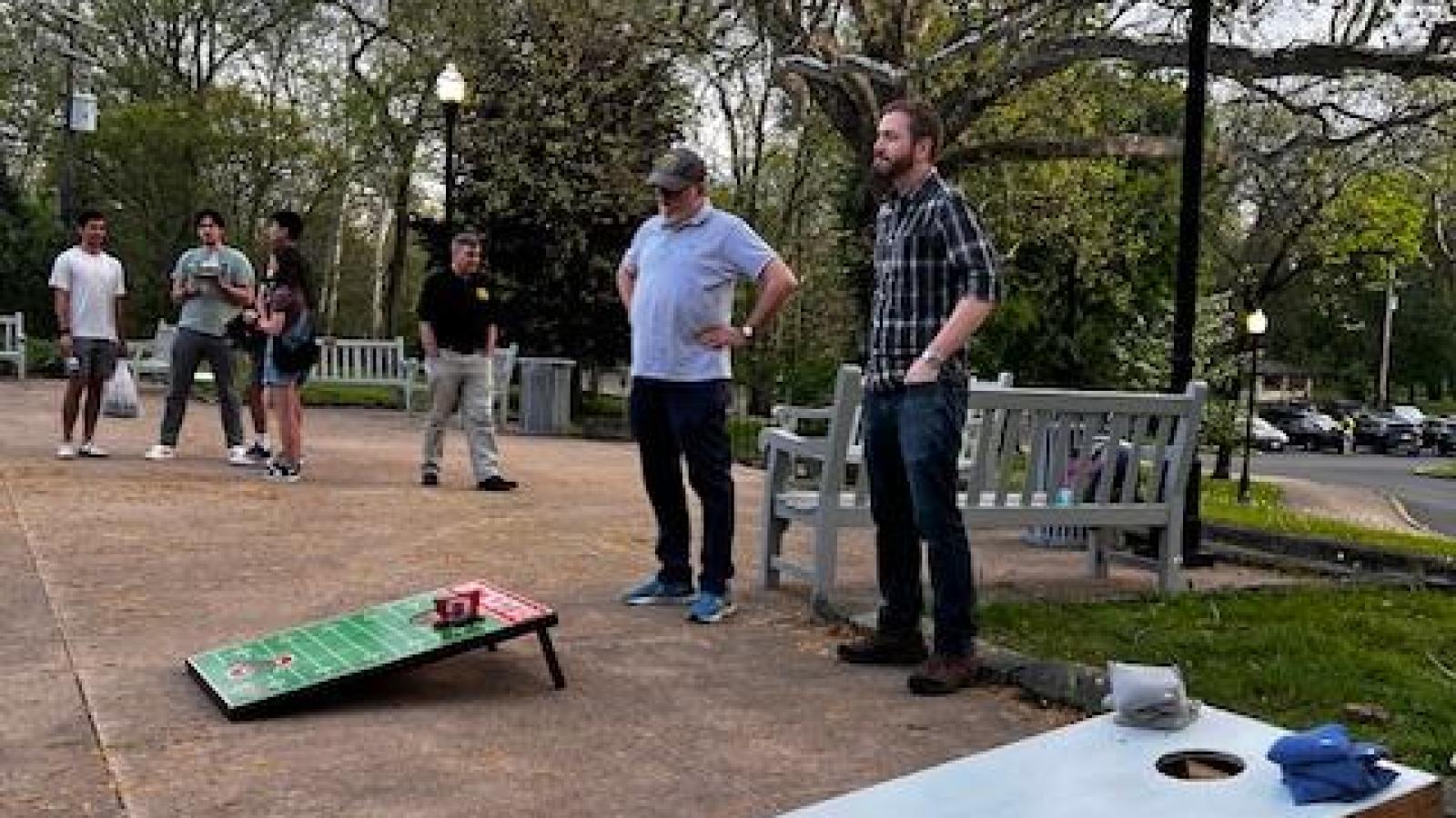 2 cornhole participants standing at a board